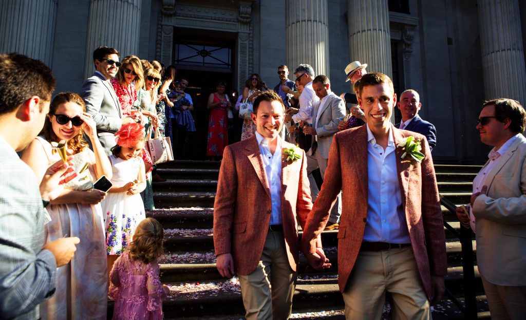 Gay couple walking down the stairs of Marylebone Town Hall
