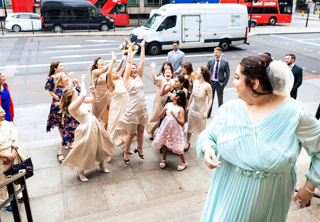 bride throwing wedding bouquet outside marylebone town hall